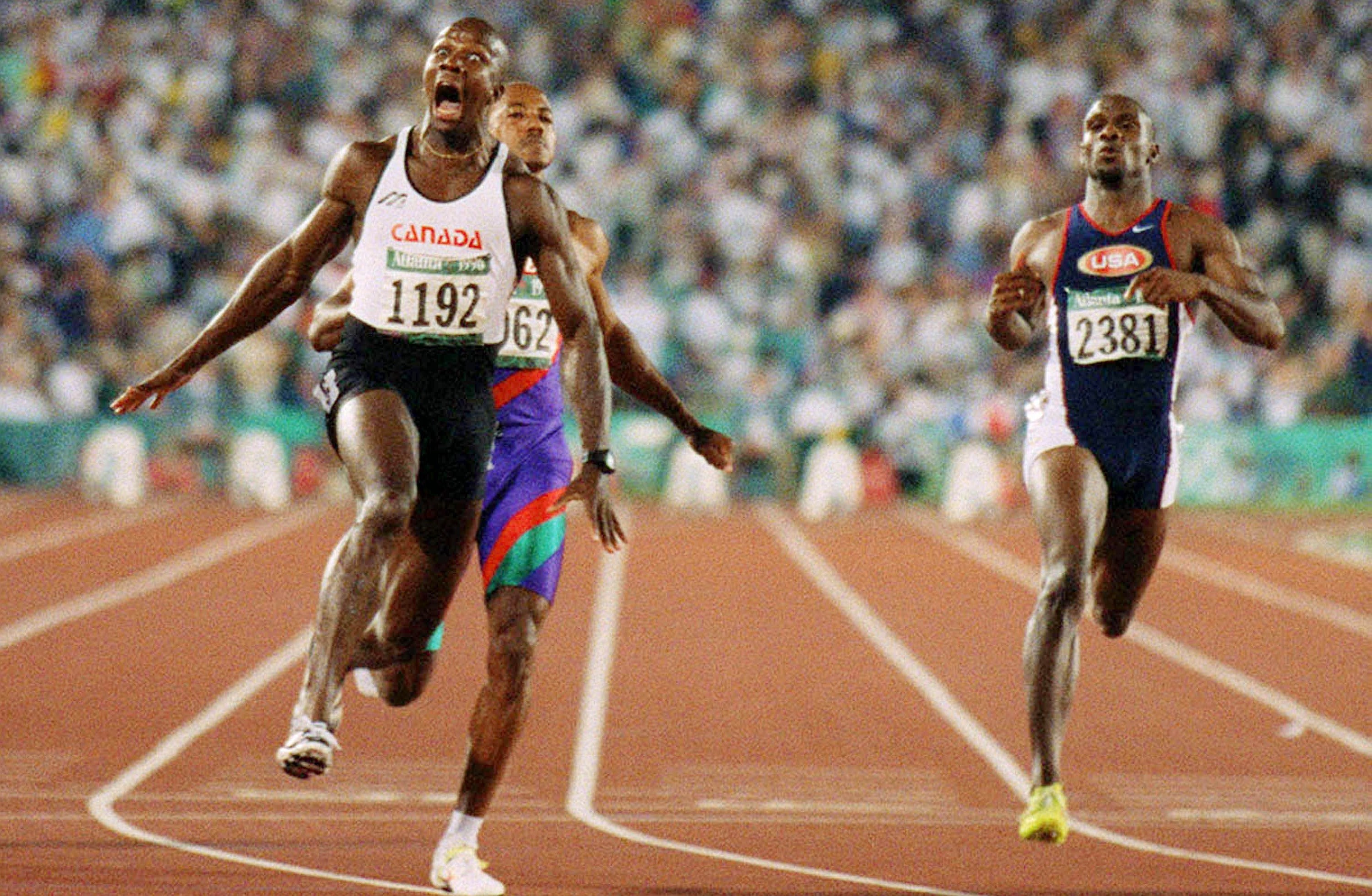 Donovan Bailey crie de joie après avoir passé le fil d'arrivé du 100 m