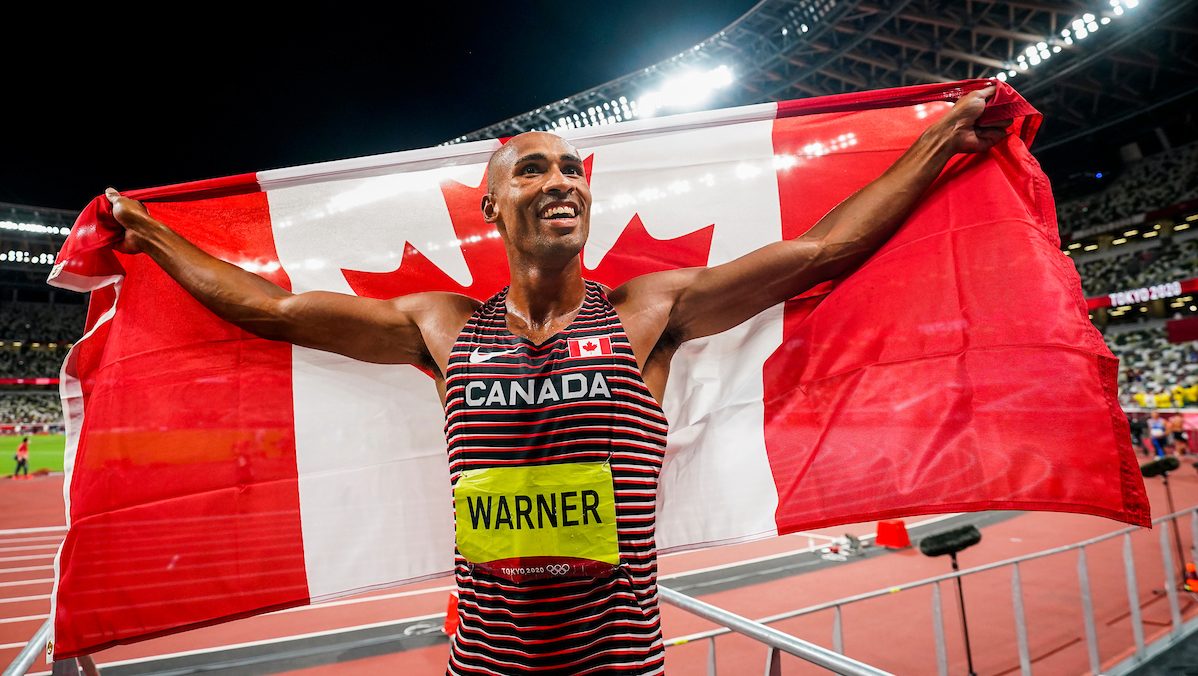 Damian Warner pose avec le drapeau canadien. 