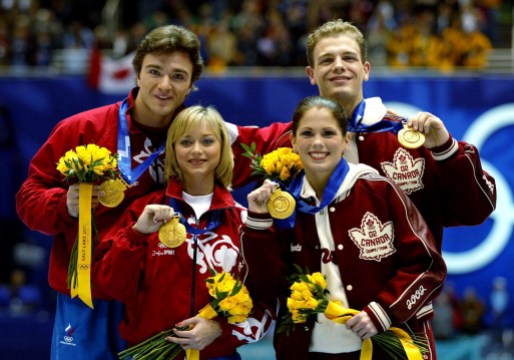 Pelletier, David | Sale, Jaime | Sikharulidze | Berezhnaya Les deux couples médaillés d'or en patinage artistique sur le podium avec leur médaille au cou et les fleurs dans les mains.