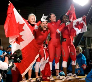 Les quatre Canadiennes célèbrent et portent plusieurs drapeaux canadiens