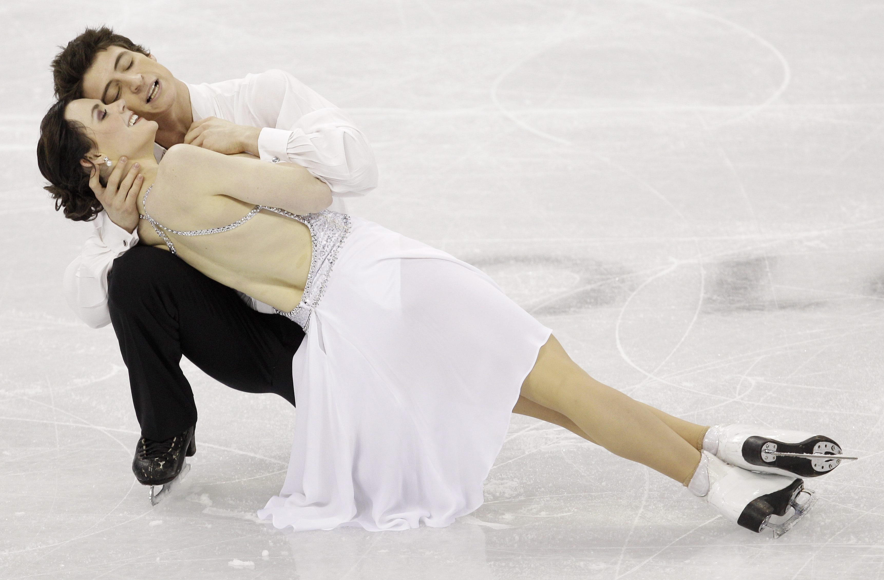 Tessa et Scott réalisent une figure, presque couchés sur la glace.