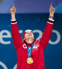 Alex Bilodeau, deux bras en l'air sur le podium et sa médaille d'or au cou