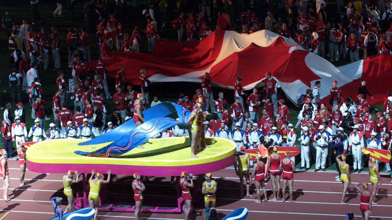 Les athlètes canadiens déroulent un drapeau géant lors de la cérémonie de clôture des Jeux de Sydney en 2000.