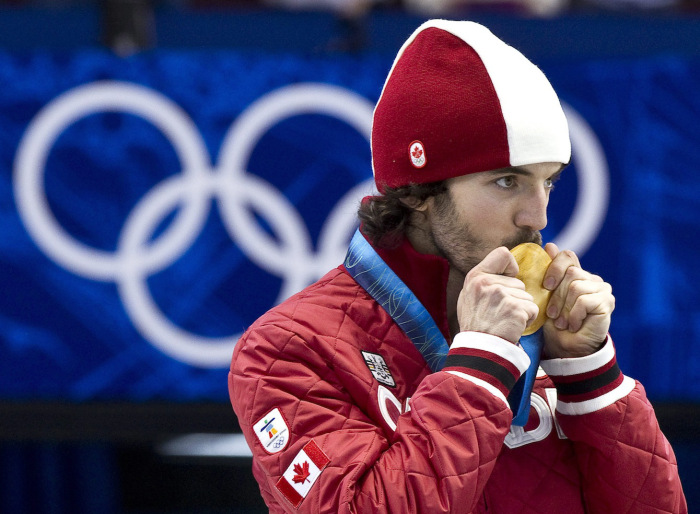 Le patineur Charles Hamelin embrassant sa médaille.