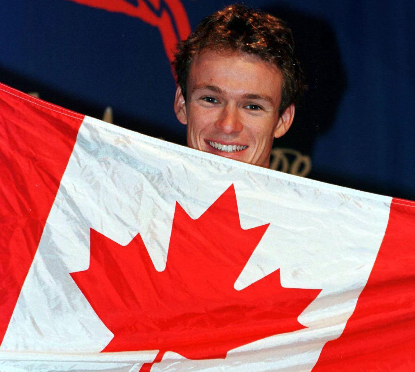 Simon Whitfield avec le drapeau canadien aux Jeux de Sydney.