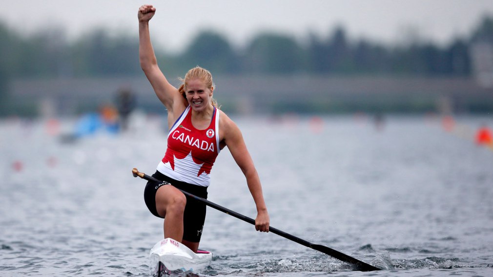 Laurence Vincent Lapointe in his canoe, raises his fist as a sign of victory.