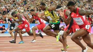 Andre De Grasse (dans le coin extérieur gauche) se penche pour capturer le bronze alors que Usain Bolt (5) et Justin Gatlin (7) se battent pour l’or et l’argent dans les derniers moments de la finale du 100 m aux Championnats du monde d’athlétisme de l’IAAF à Beijing en Chine le 23 août 2015.