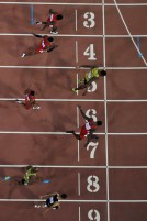 Andre De Grasse (couloir neuf) se penche pour capturer le bronze alors que Usain Bolt (5) et Justin Gatlin (7) se battent pour l’or et l’argent dans les derniers moments de la finale du 100 m aux Championnats du monde d’athlétisme de l’IAAF à Beijing en Chine le 23 août 2015.