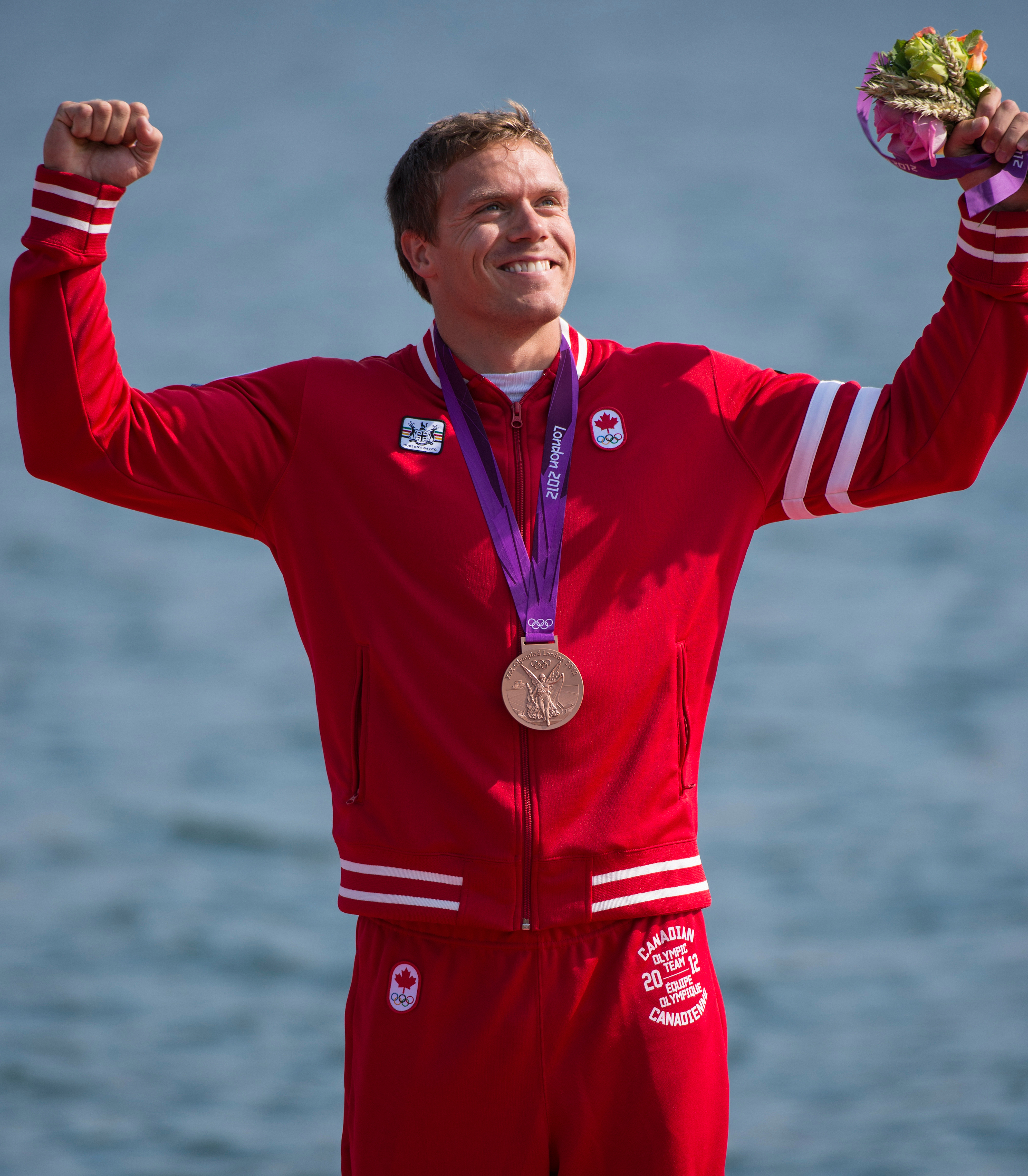 Un athlète célèbre sa médaille les poings dans les airs
