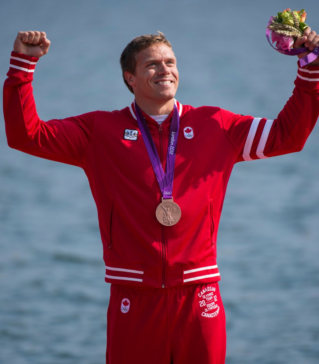 Un athlète célèbre sa médaille les poings dans les airs