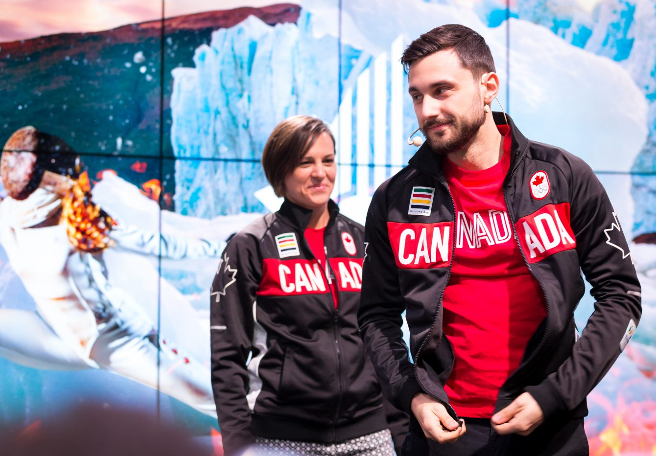 Joseph Polossifakis enfile sa veste d'équipe en présence de la chef de mission adjointe Isabelle Charest.