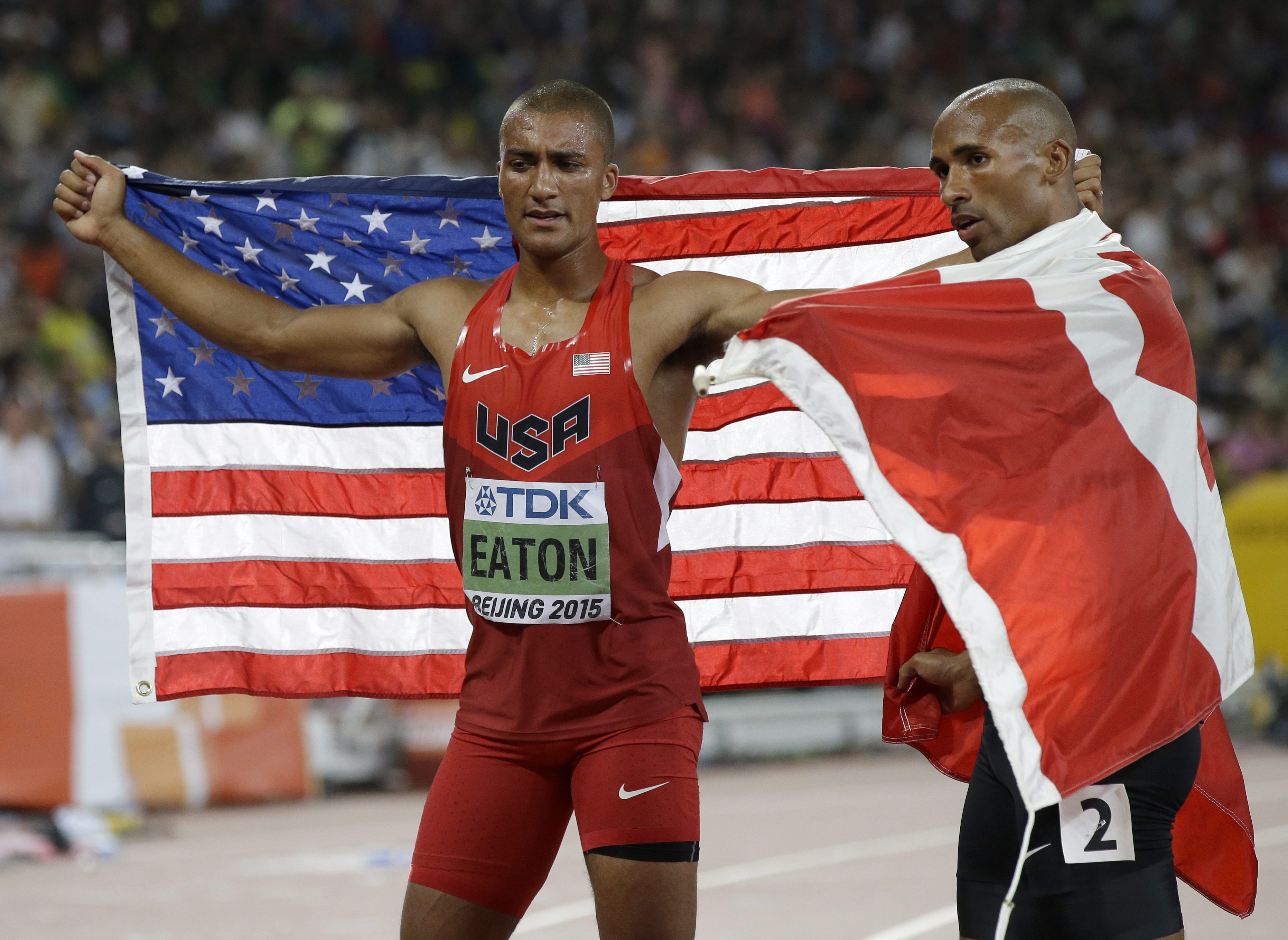 Damian Warner (à droite) en compagnie de l'Américain Ashton Eaton lors du tour d'honneur aux Mondiaux d'athlétisme, le 29 août 2015 à Beijing.(AP Photo/Kin Cheung)