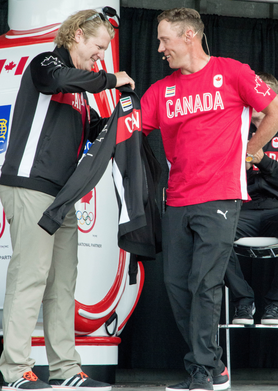 Graham DeLaet enfilant la veste d'Équipe Canada, le 19 juillet 2016 lors de l'annonce de l'équipe de golf au Glenn Abbey Golf Club. (Tania Barkowski / COC)