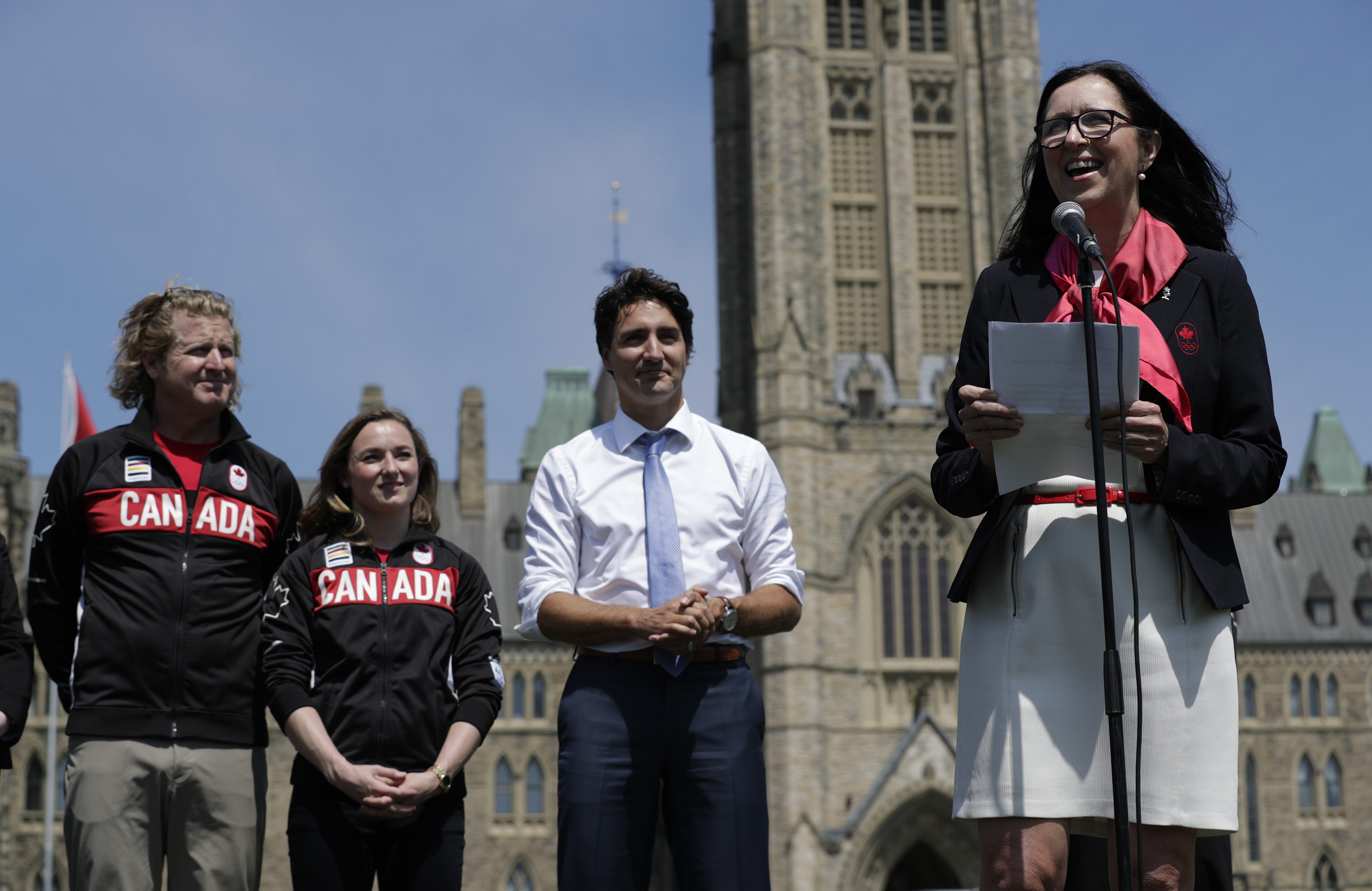 Curt Harnett, Rosie MacLennan, Justin Trudeau et Tricia Smith (au micro) lors du dévoilement du porte-drapeau à la Colline du parlement, le 21 juillet 2016 à Ottawa.