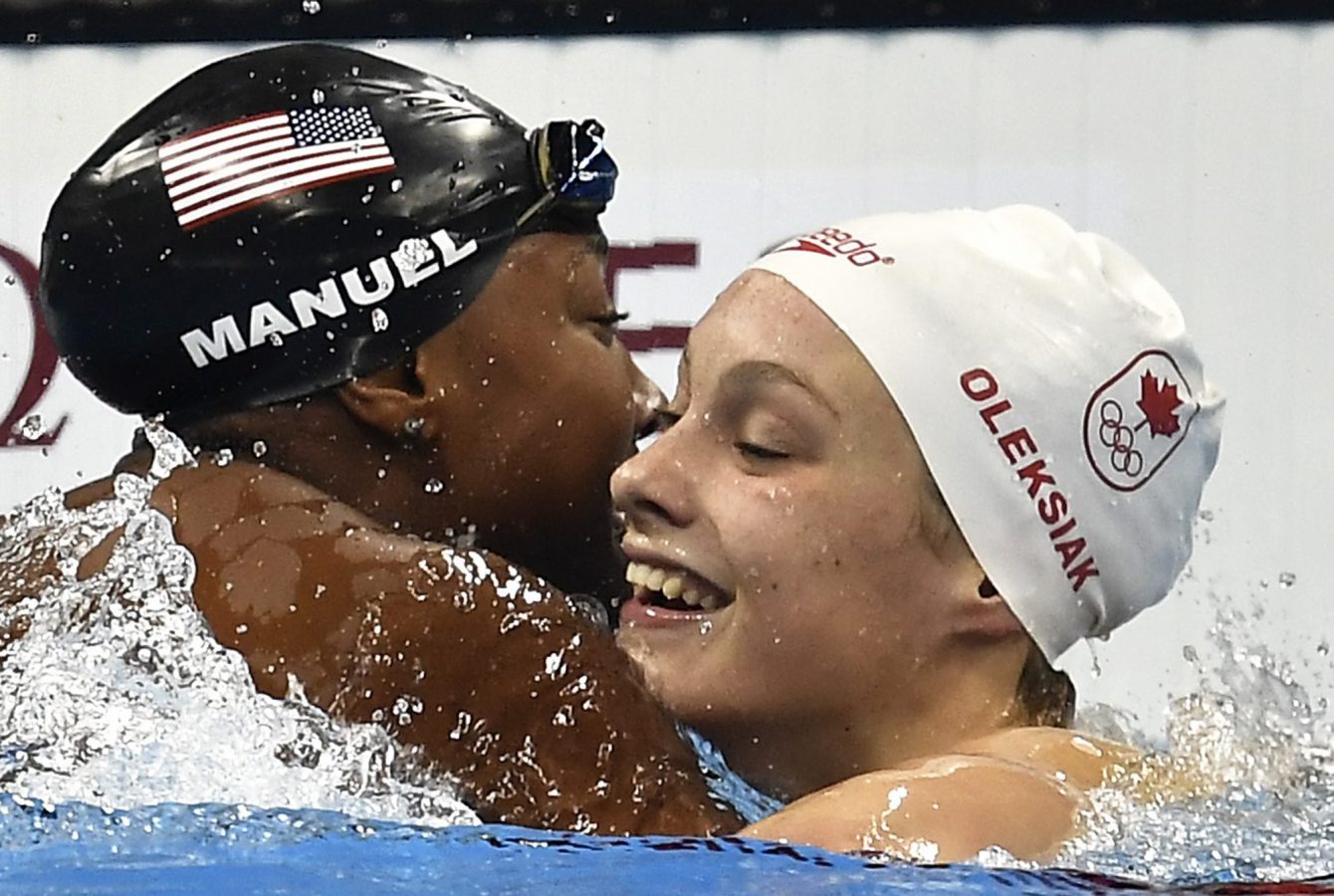 Penny Oleksiak célèbre sa médaile d'or avec l'Américaine Simone Manuel, au 100 m style libre. AP Photo/Martin Meissner