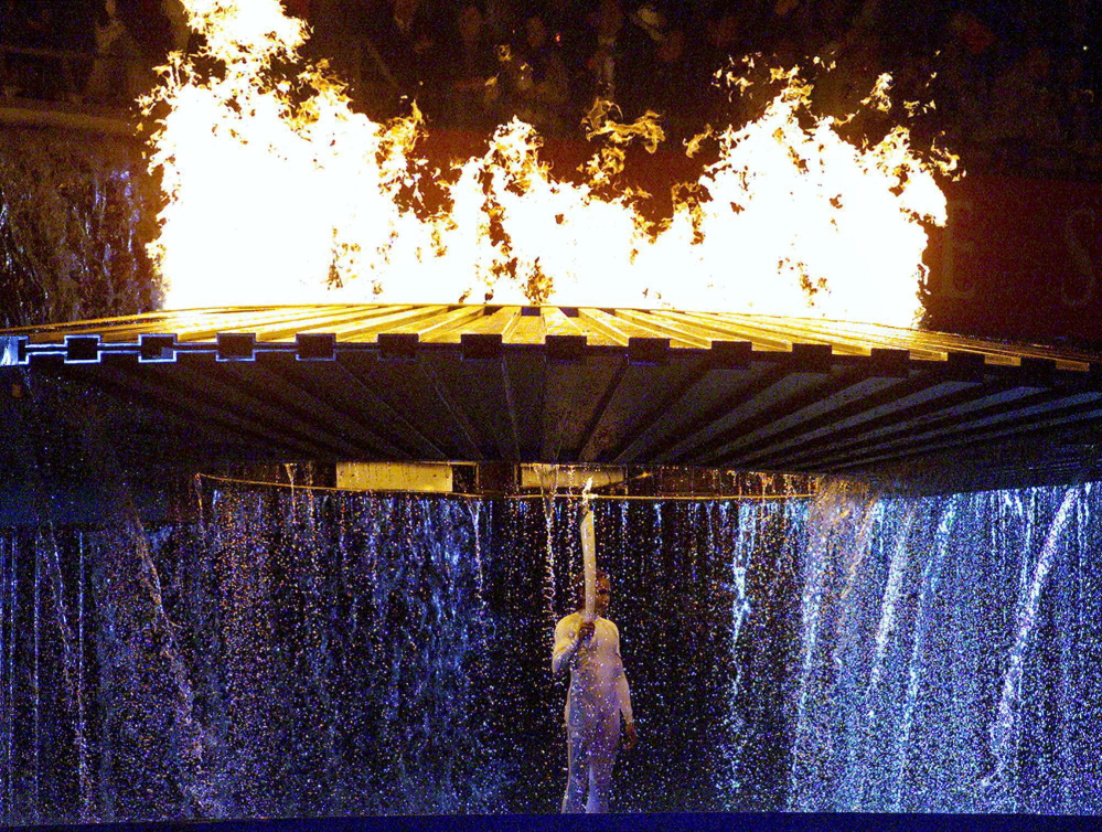 Cathy Freeman se tient sous la flamme olympique lors de la cérémonie d'ouverture des Jeux olympiques de Sydney 2000.