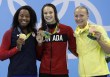 Les médaillées d'or du 100 m style libre Simone Manuel (gauche) et Penny Oleksiak (centre) avec la médaillée de bronze Sarah Sjostrom (droite) posent pour un photographe lors de la cérémonie des médailles. Jeux de Rio, 11 août 2016. (AP Photo/Michael Sohn)