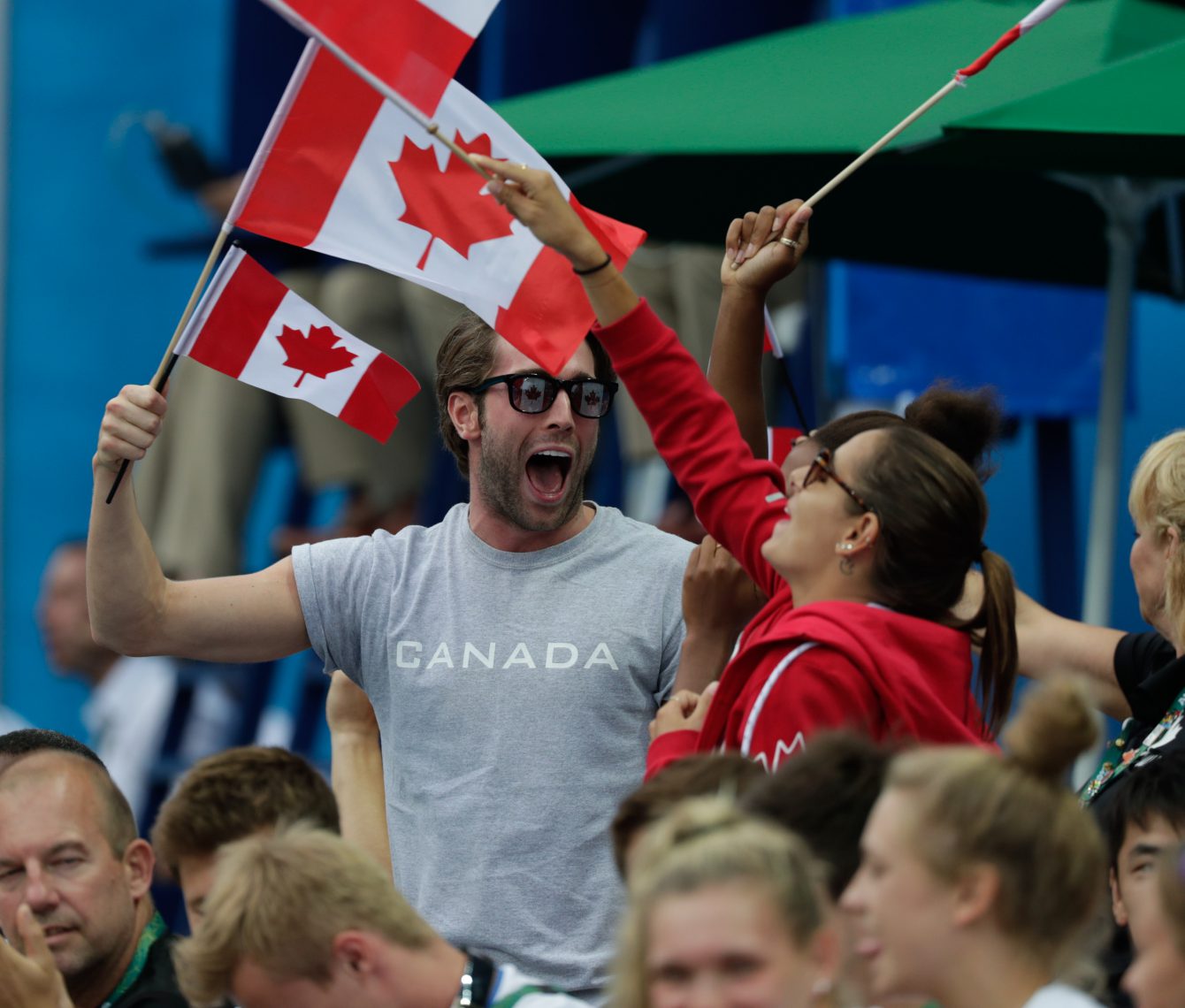Maxim Bouchard et Pamela Ware encouragent Meaghan Benfeito et Roseline Filion lors de la finale du 10 m individuel aux Jeux olympiques de Rio, le 18 août 2016. Photo: COC/Jason Ransom