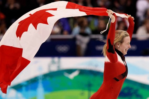 marianne St-Gelais fait un tour de piste sur la glace en portant le drapeau canadien, è Vancouver 2010.