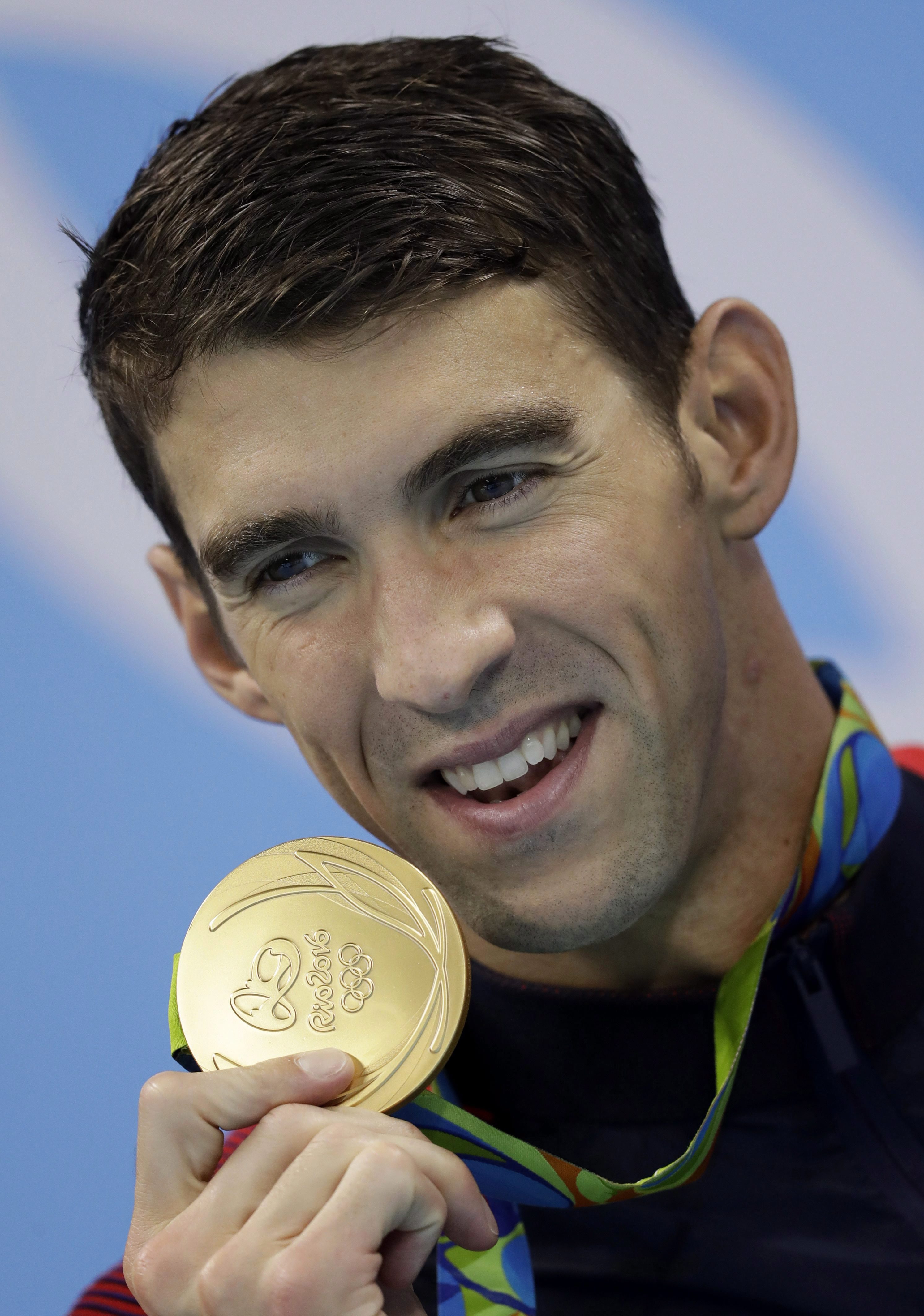Michael Phelps et sa médaille d'or après la finale masculine de relais 4 x 100 mètres lors des compétitions de natation aux Jeux olympiques d'été de 2016 à Rio de Janeiro, le 14 août 2016. (AP Photo / Michael Sohn)