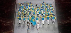 Yerdos Akhmadiyev du Kazakhstan porte le drapeau national et alors qu'il entre dans le stade avec ses coéquipiers lors de la cérémonie d'ouverture des Jeux olympiques d'hiver de 2014 à Sotchi, en Russie, le vendredi 7 février 2014. (AP Photo / Charlie Riedel)