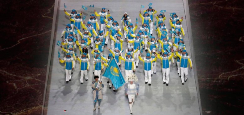 Sochi Olympics Opening Ceremony Yerdos Akhmadiyev du Kazakhstan porte le drapeau national et alors qu'il entre dans le stade avec ses coéquipiers lors de la cérémonie d'ouverture des Jeux olympiques d'hiver de 2014 à Sotchi, en Russie, le vendredi 7 février 2014. (AP Photo / Charlie Riedel)