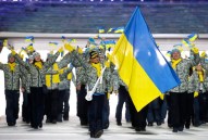 Valentina Shevchenko d'Ukraine porte le drapeau national alors qu'elle mène ses coéquipiers lors de la cérémonie d'ouverture des Jeux olympiques d'hiver de 2014 à Sotchi, en Russie, le vendredi 7 février 2014. (AP Photo / Mark Humphrey)