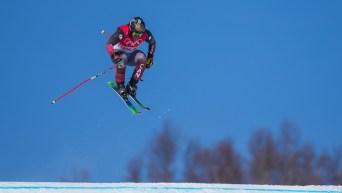Un skieur de ski cross en plein saut lors d'une descente