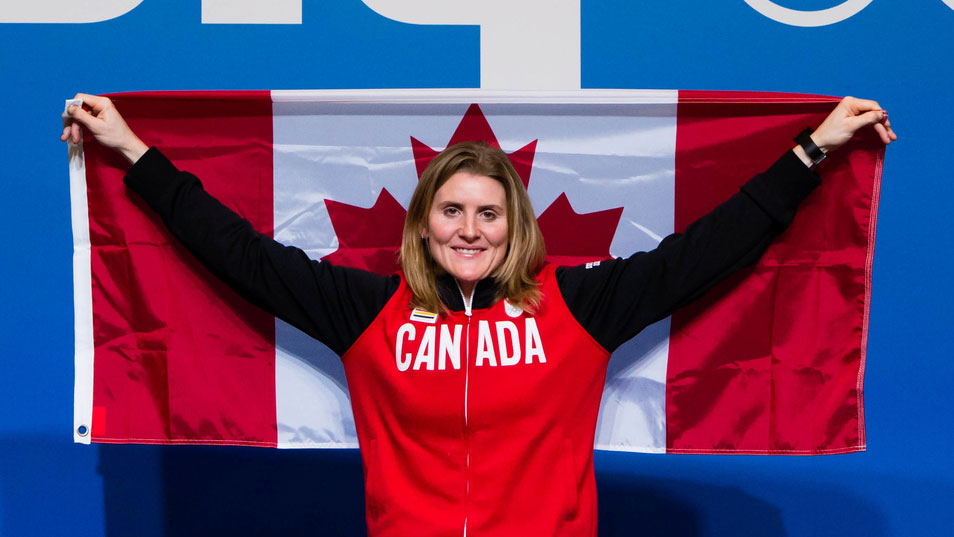Hayley Wickenheiser tient un drapeau canadien.