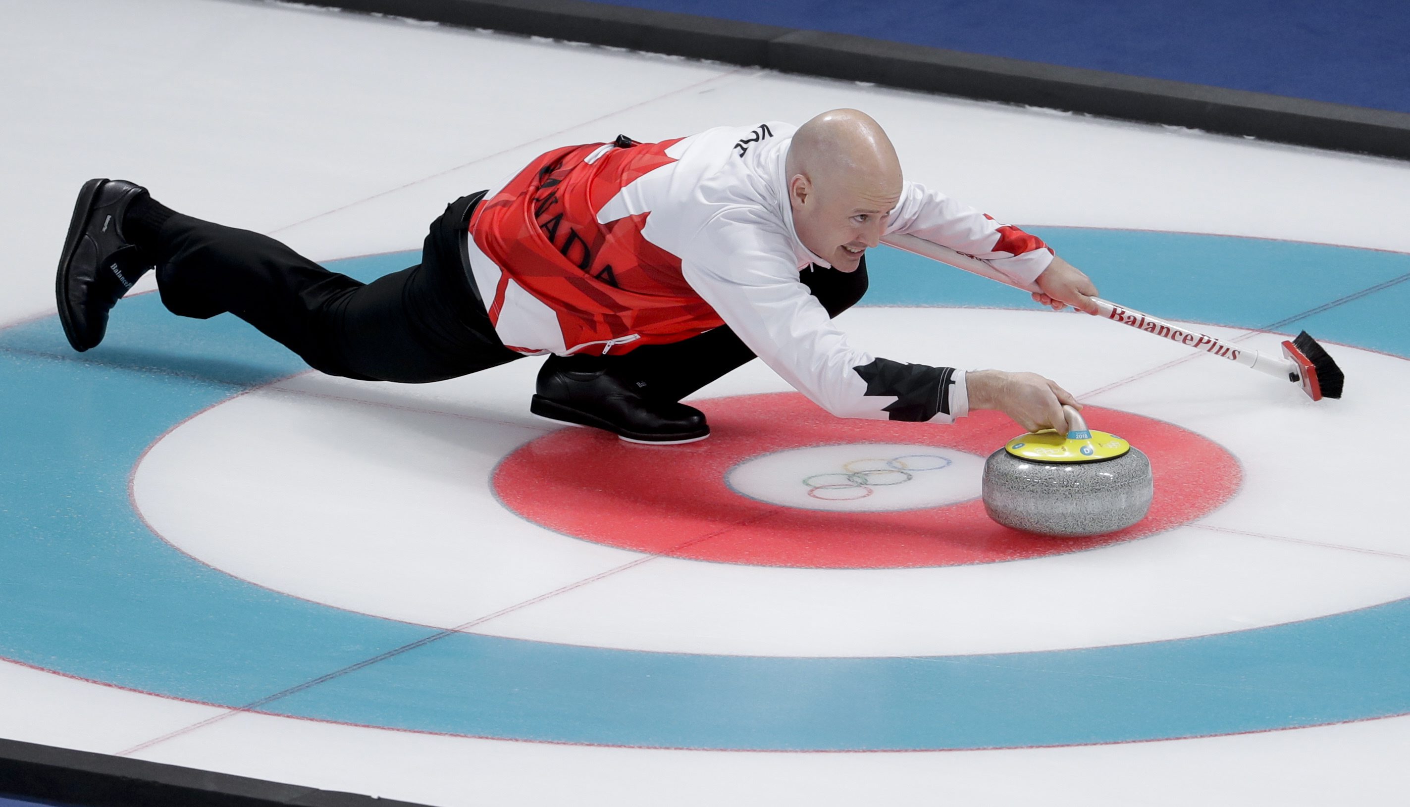 Le capitaine Kevin Koe lance une pierre lors du match contre les Suisses. (AP Photo/Natacha Pisarenko)