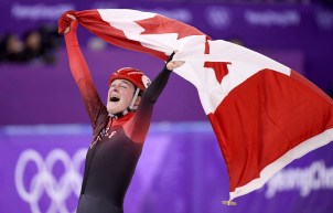 Kim Boutin célèbre en soulevant le drapeau canadien