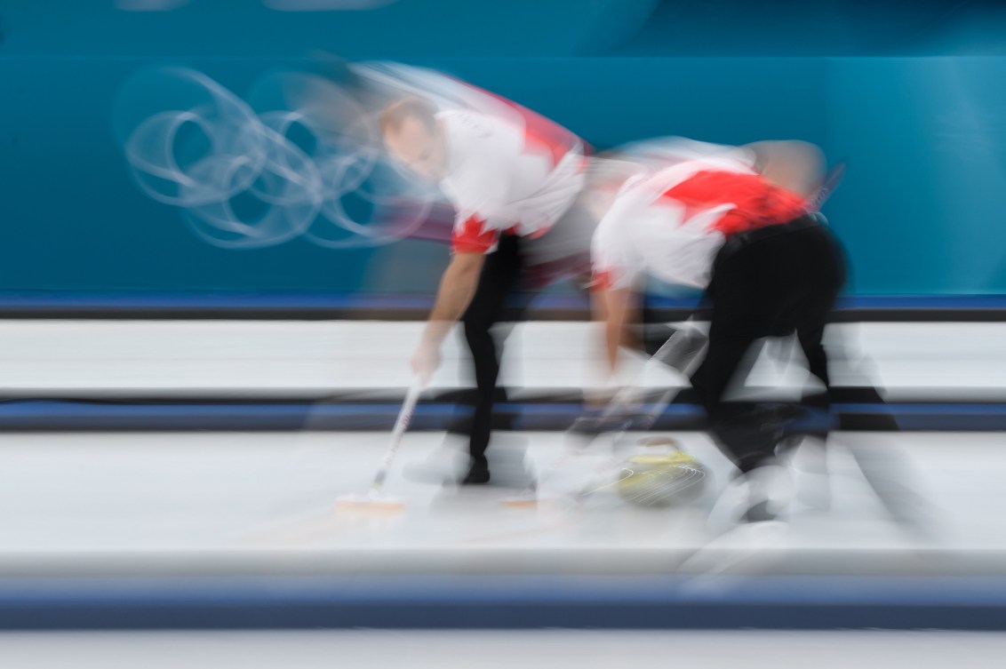 Deux joueurs de curling en action.