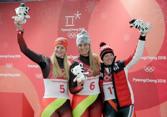 De gauche à droite, la médaillée d'argent Dajana Eitberger de l'Allemagne, la médaillée d'or Natalie Geisenberger de l'Allemagne, et Alex Gough, médaillée de bronze, à l'épreuve simple de luge aux Jeux olympiques de PyeongChang, le 13 février 2018. (AP Photo/Wong Maye-E)