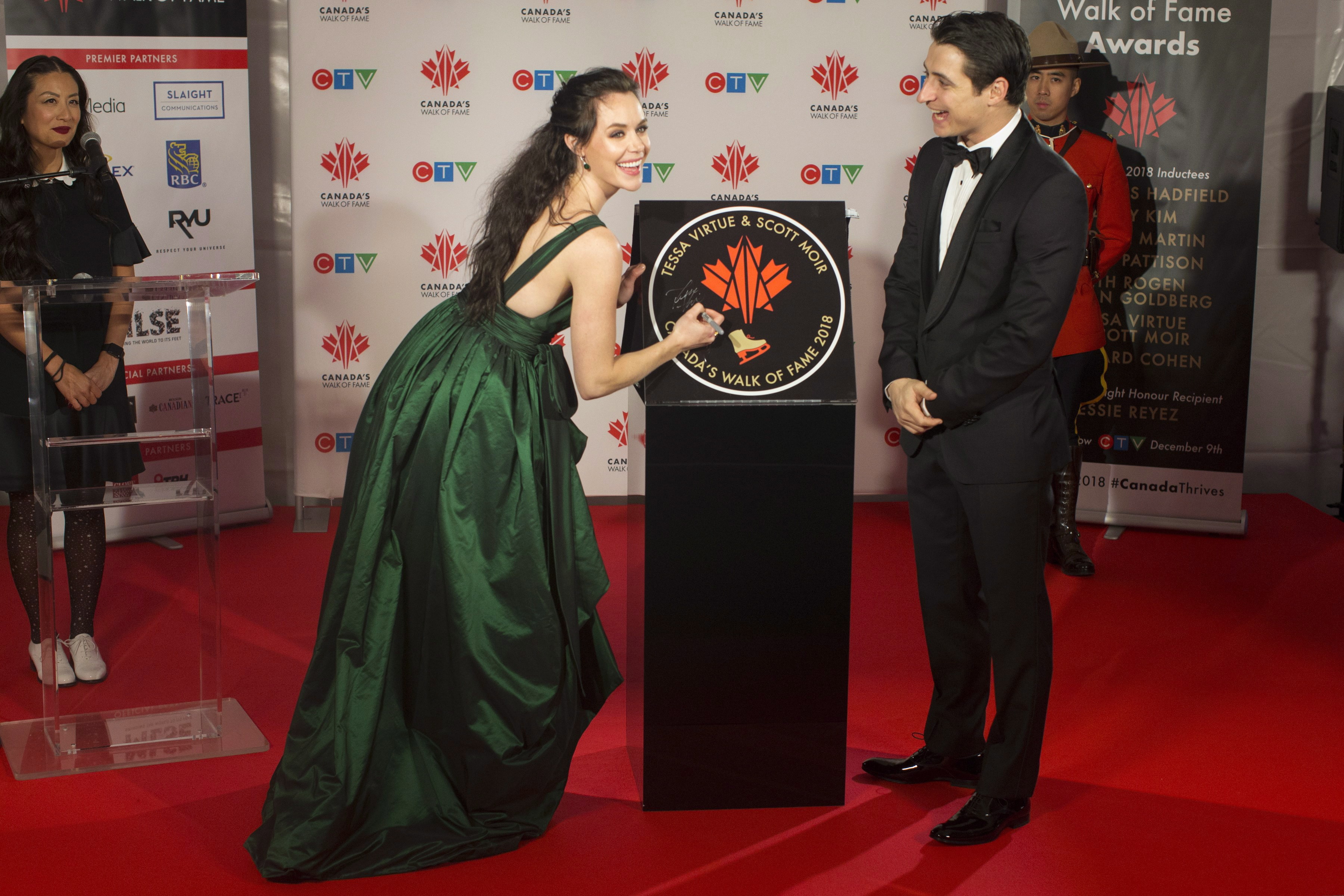 Tessa Virtue et Scott Moir signent leur étoile lors de leur intronisation à l'Allée des célébrités canadiennes, le 1er décembre 2018, à Toronto. LA PRESSE CANDIENNE/Chris Young