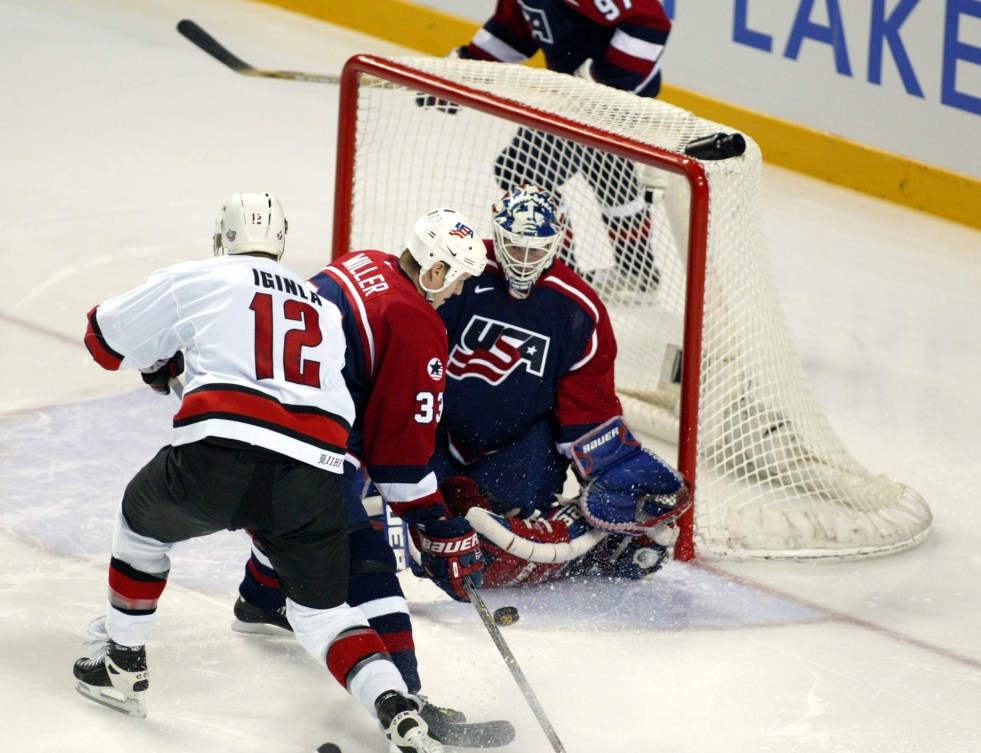 Un joueur de hockey devant un gardien de but.