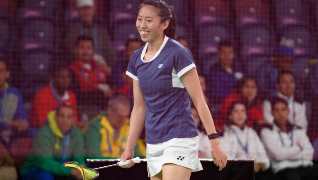 Une joueuse de badminton sourit en plein match
