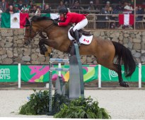 Un cavalier d'Équipe Canada et sa monture sautent par dessus un obstacle à Lima 2019