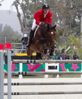 Un cavalier d'Équipe Canada et sa monture sautent par dessus un obstacle à Lima 2019
