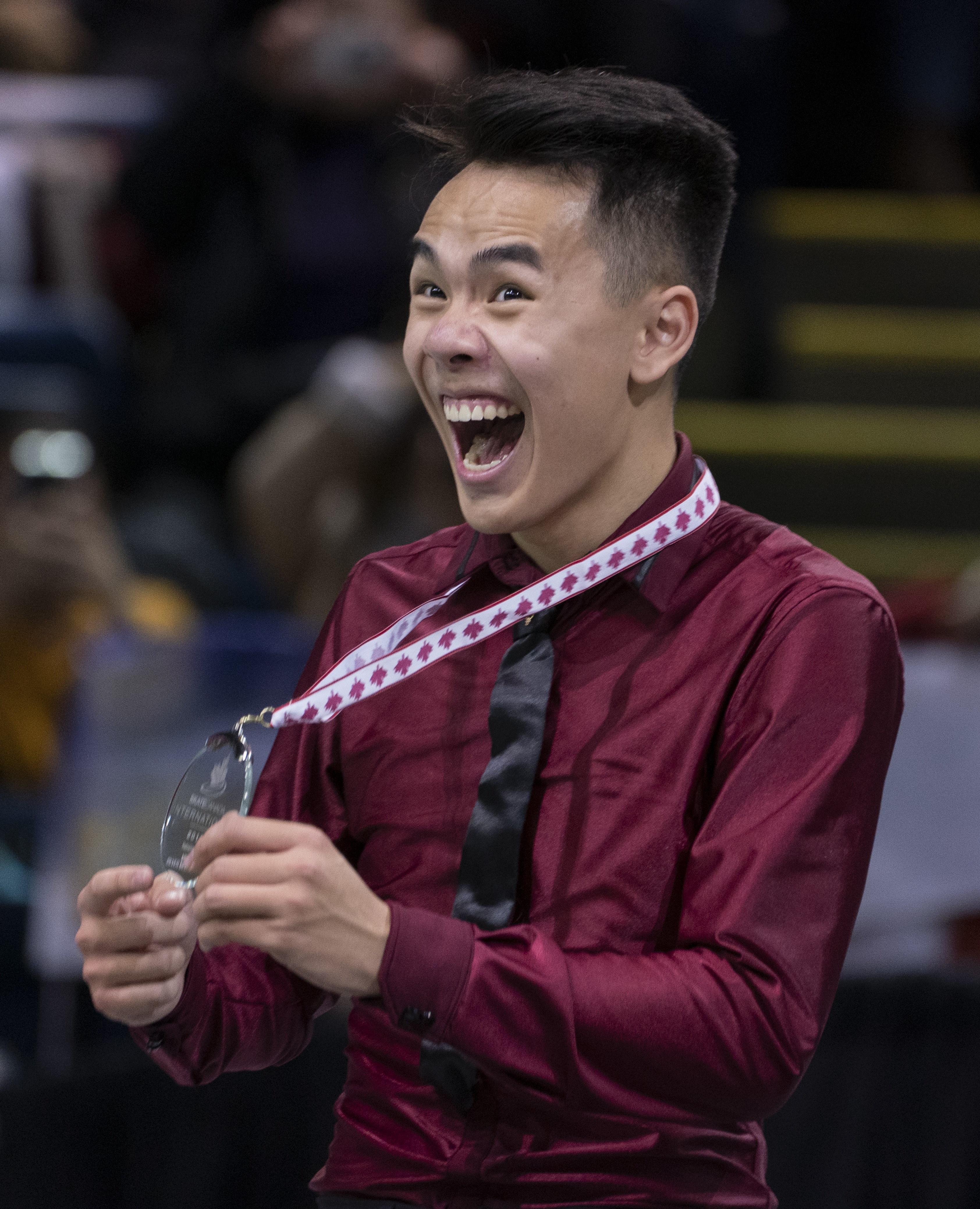 Nam Nguyen fait un grand sourire en montrant sa médaille d'argent.