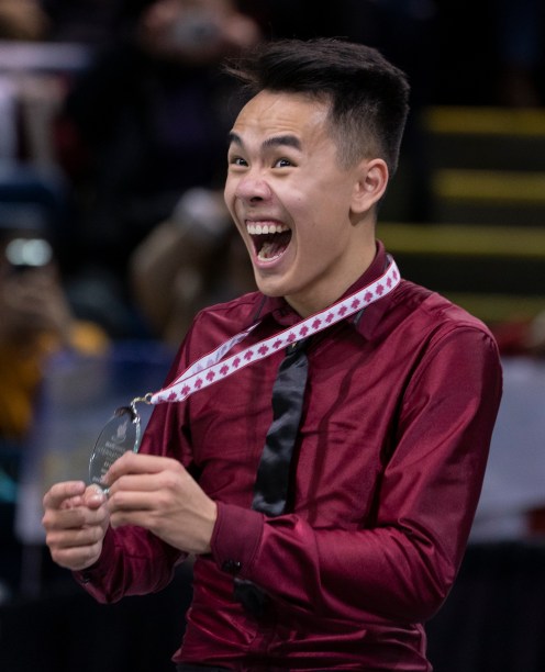 Nam Nguyen fait un grand sourire en montrant sa médaille d'argent.