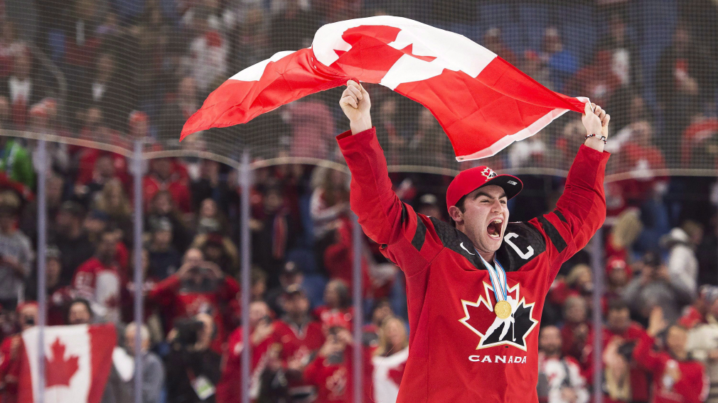 Dillon Dubé réagit et pote le drapeau canadien après une victoire