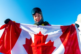 Liam Brearley pose avec le drapeau canadien à Lausanne 2020
