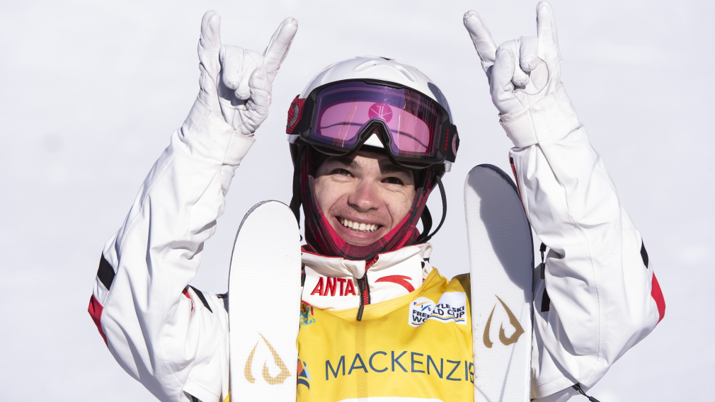 Un skieur fait des signes de rock avec ses mains