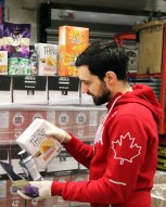 Joseph Polossifakis aide a déballer les produits de la cargaison d'Équipe Canada. (MOISSON MONTRÉAL/ALEXANDRA GRENIER)