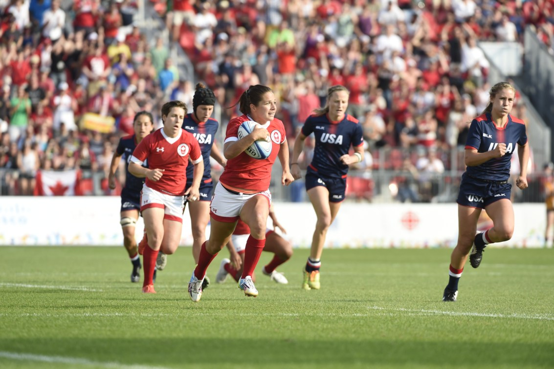 Canadian player runs with ball during rugby match