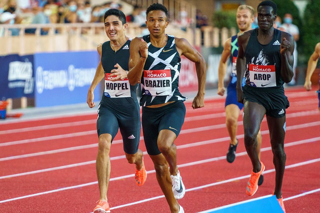 Trois coureurs luttent pour la première place sur une piste d'athétisme