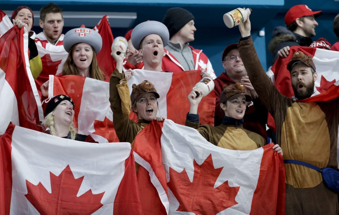 Des fans dans les estrades lèvent des drapeaux du Canada