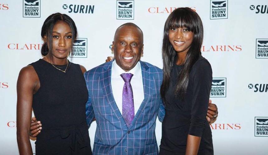 Bruny Surin pose, entouré de ses deux filles