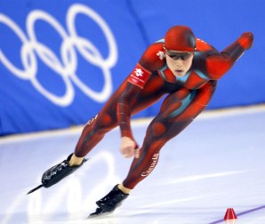 Une patineuse fait des croisés dans la courbe d'un anneau olympique