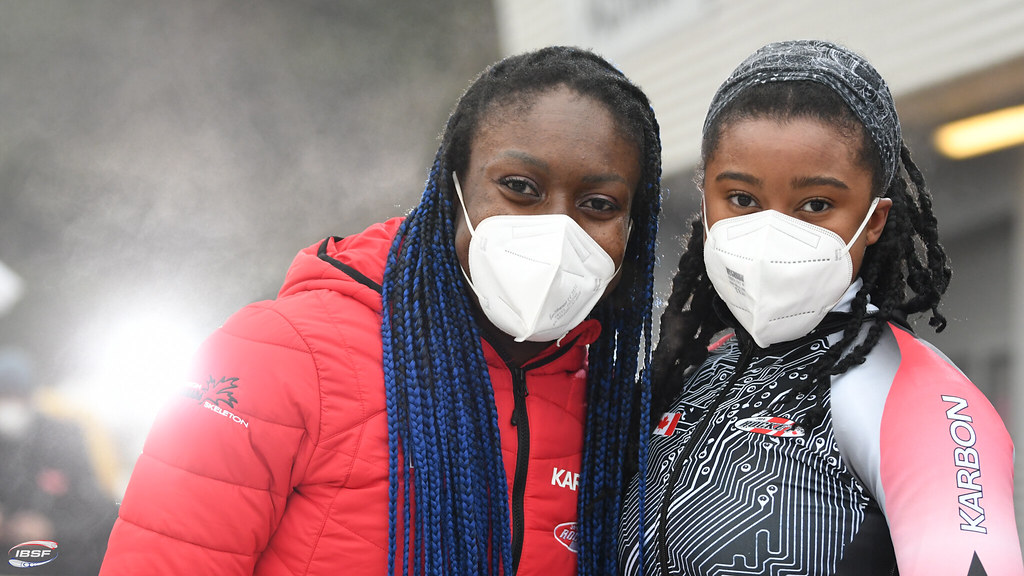 Deux athlètes portant un masque sanitaire regardent la caméra.